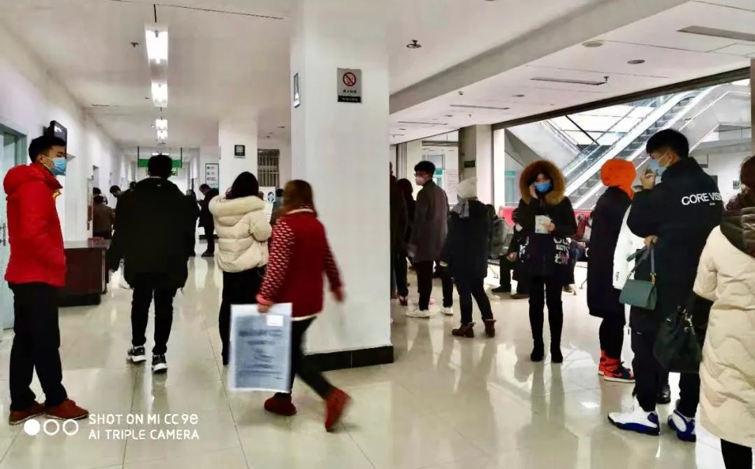 年前的安陆市普爱医院里,大家戴着口罩排队做检查